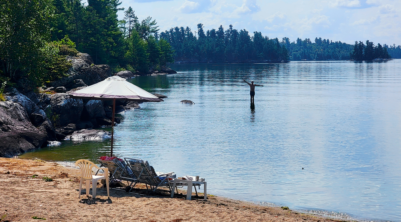 Person on beach with someone waving from water