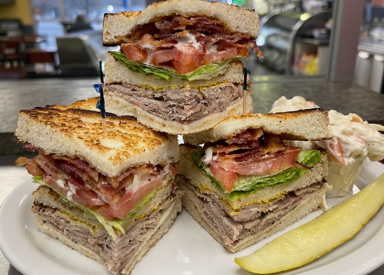thick porketta sandwiches stacked up with a side of pickle at Cara's Convenience in Sudbury. 
