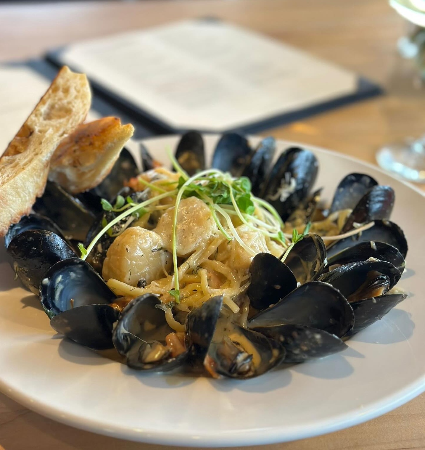 creamy pasta with scallops surrounded with steamed mussels and garlic baguette from Embers in Sault Ste. Marie. 