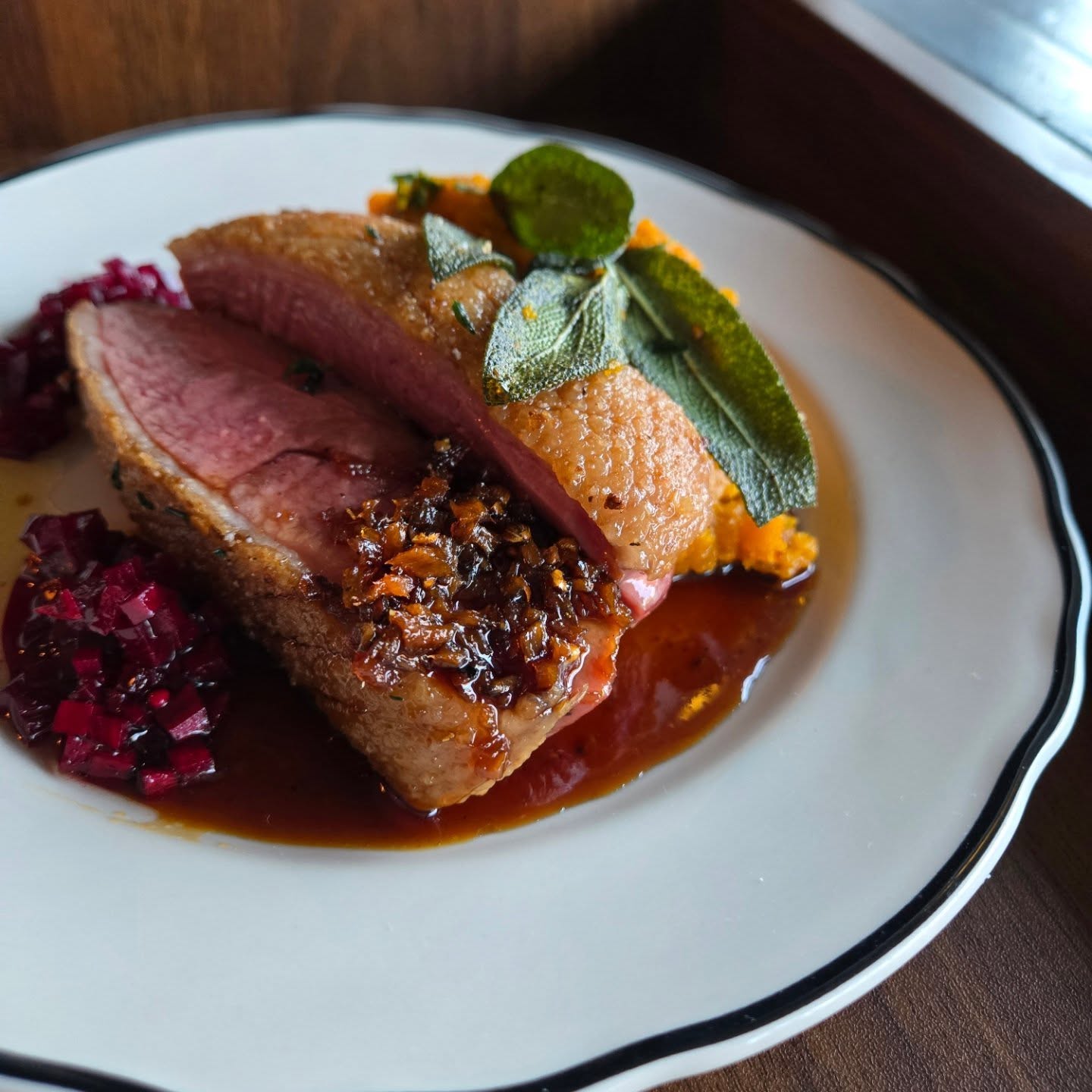 pan-seared crispy duck with squash, pickled beet and ginger glaze from Ernie's Coffee Shop.