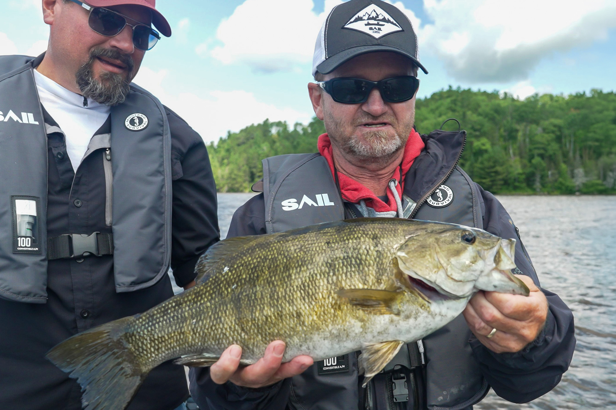 anglers holding smallmouth bass