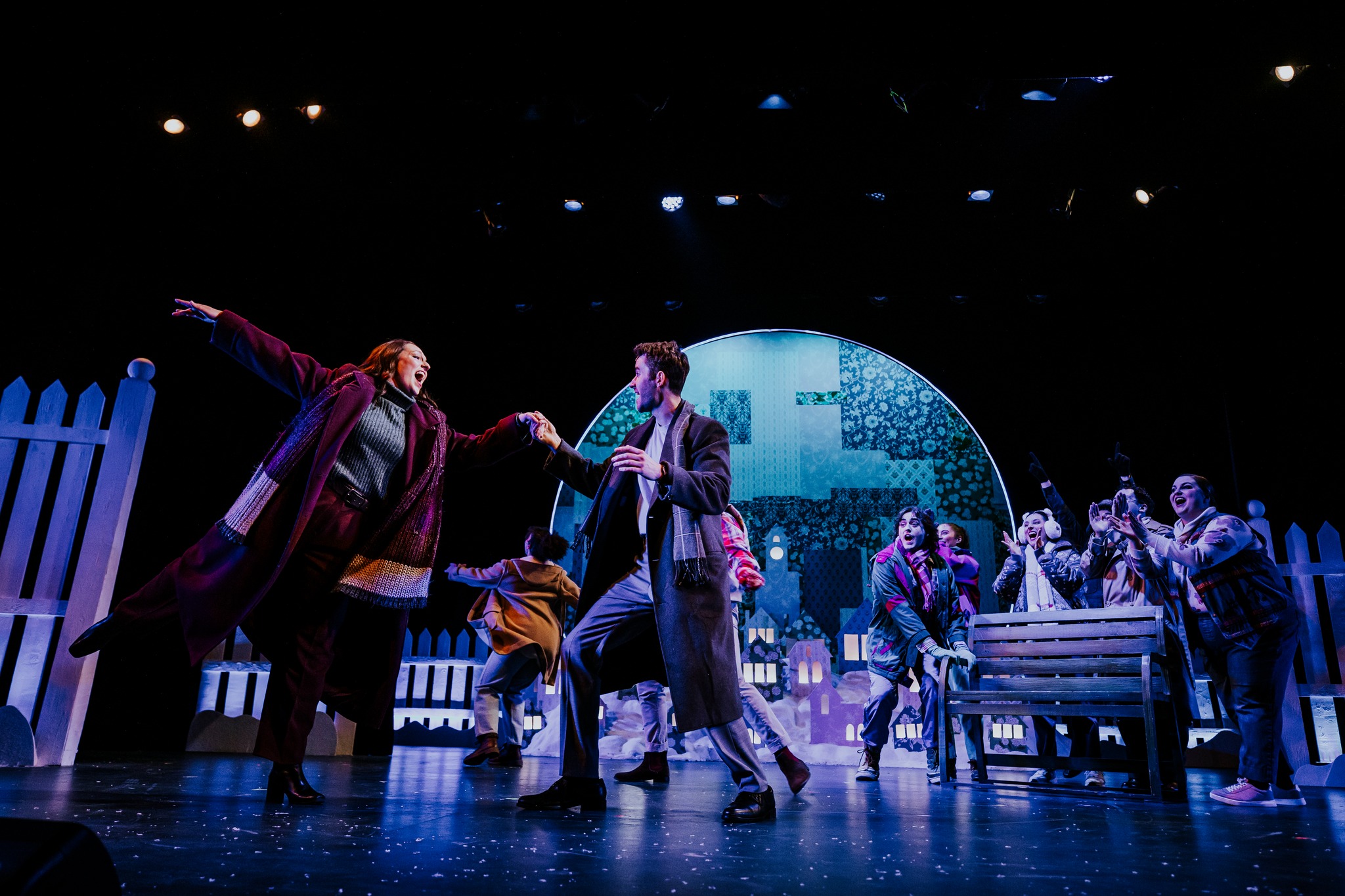 a group of actors smiling and dancing on stage during a YES Theatre production of Groundhog Day in Sudbury. 