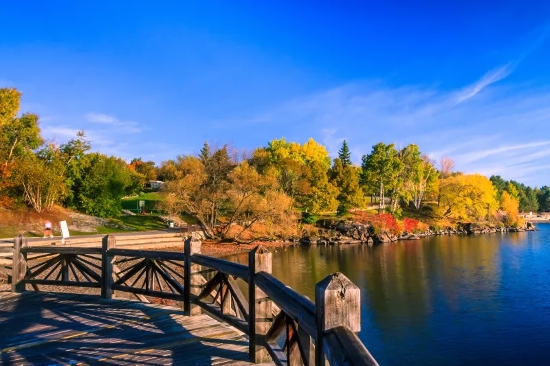 Ramsey Lake reflecting a bright blue sky and vibrant fall foliage.