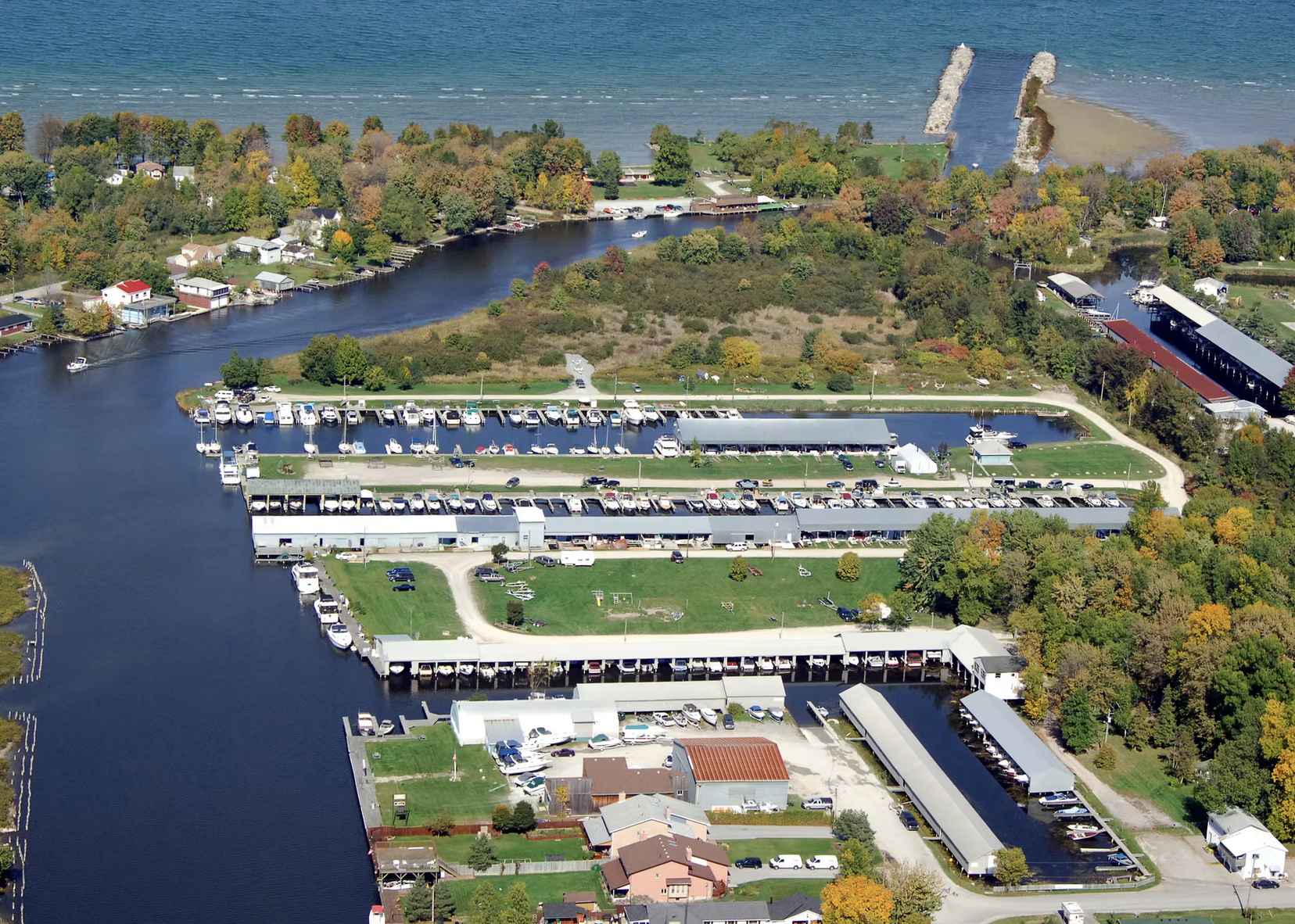 A sprawling Everglades Marina, with ample uncovered and covered slips surrounded by autumn forest.