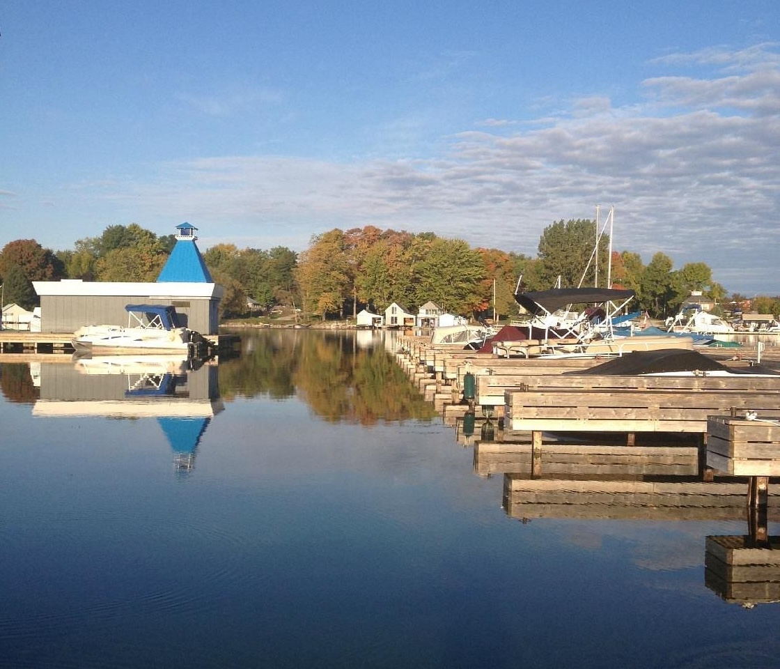 rows of wooden boat slips on glassy clear water at a quiet Blue Beacon Marina.