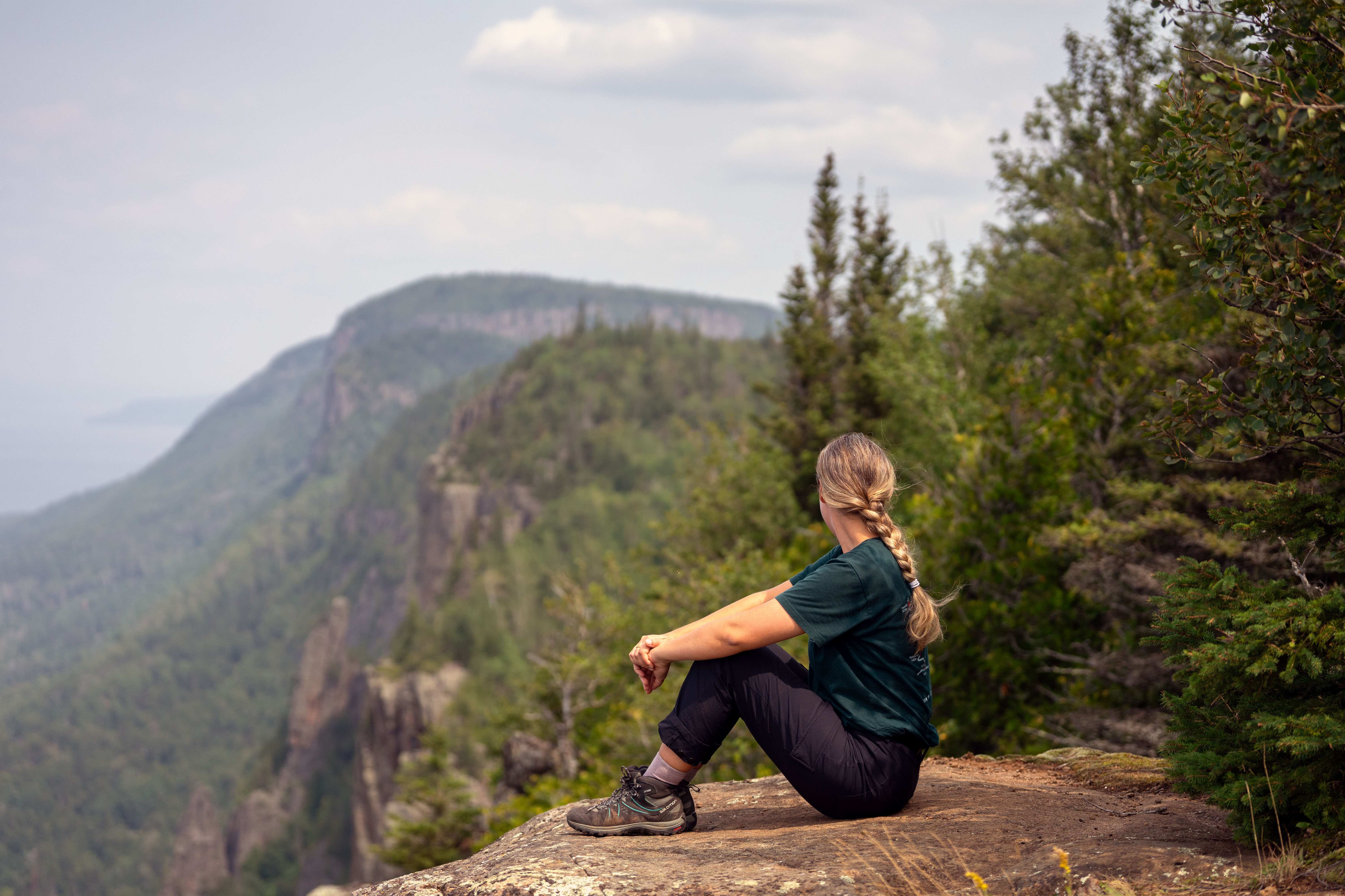 A woman looks out over the Sleeping Giant cliffs