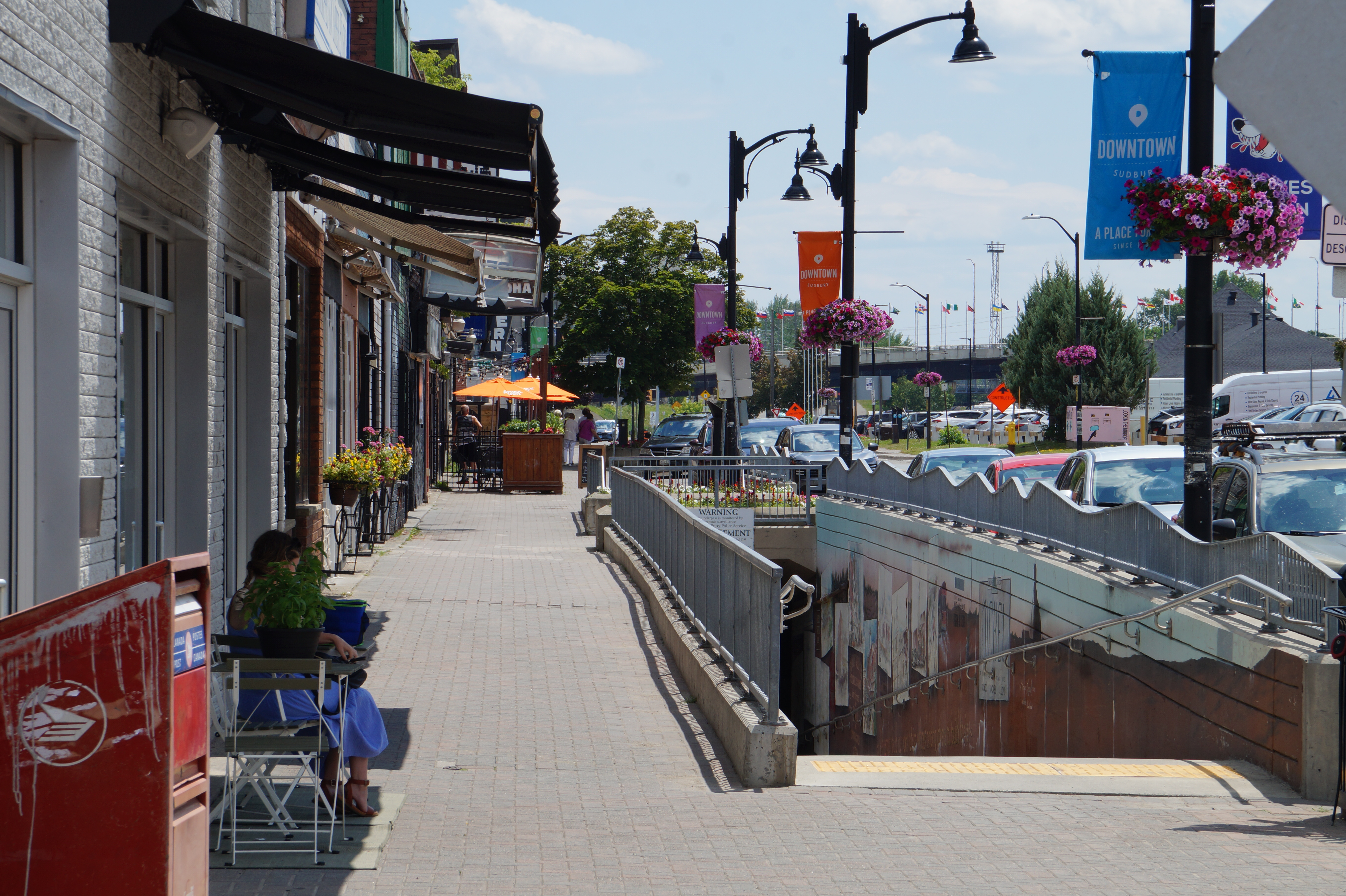 a quiet downtown Sudbury street and stairs leading to the underground pedestrian tunnel on a clear blue summer day.