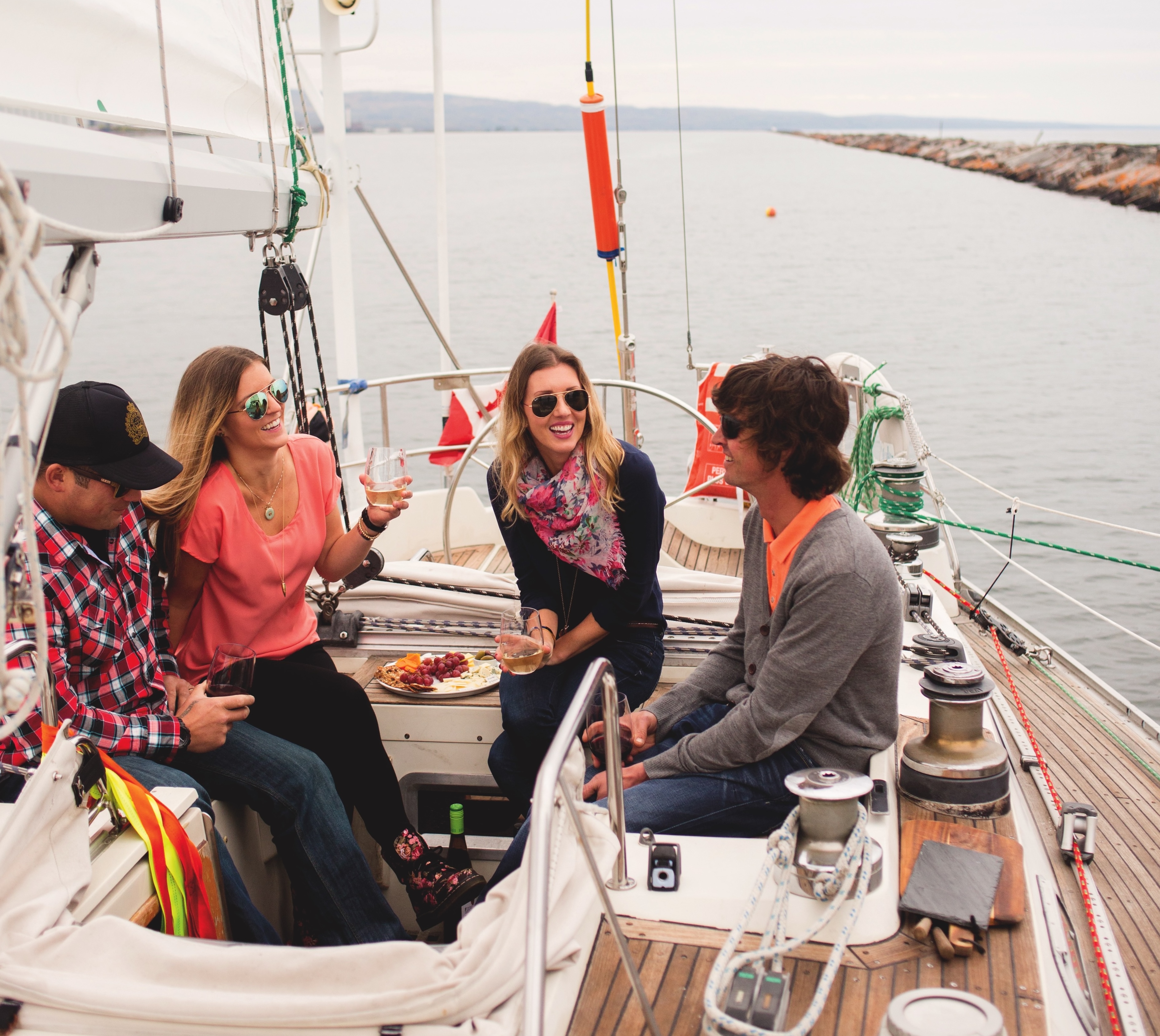 people chat and taste wine and cheese aboard a windswept sailboat on Lake Superior.