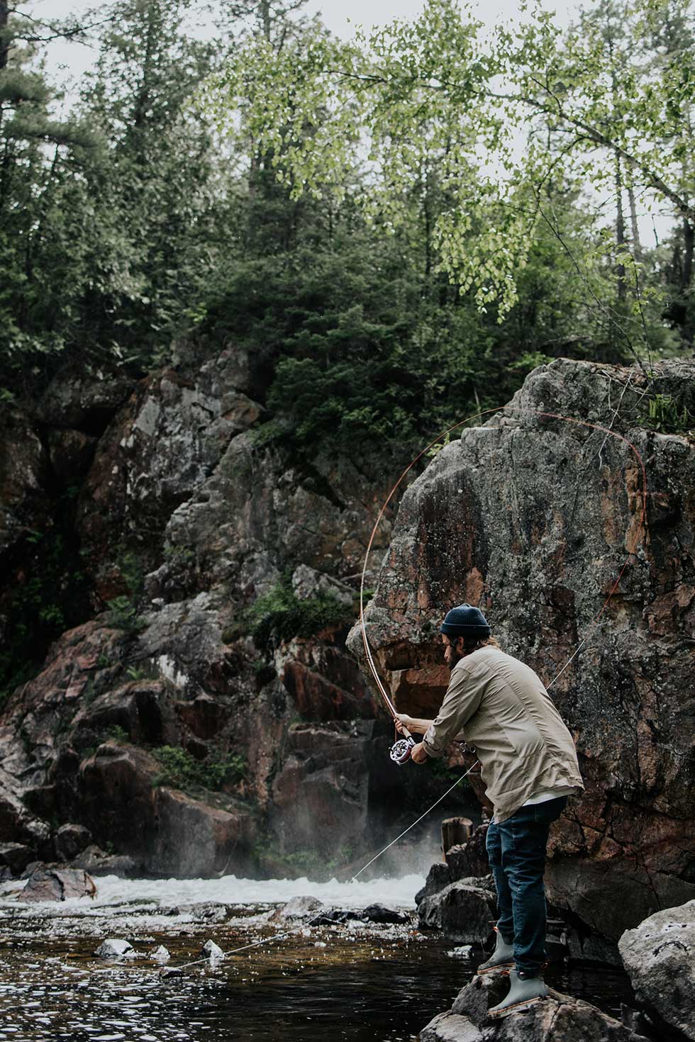 fly fishing by a waterfall