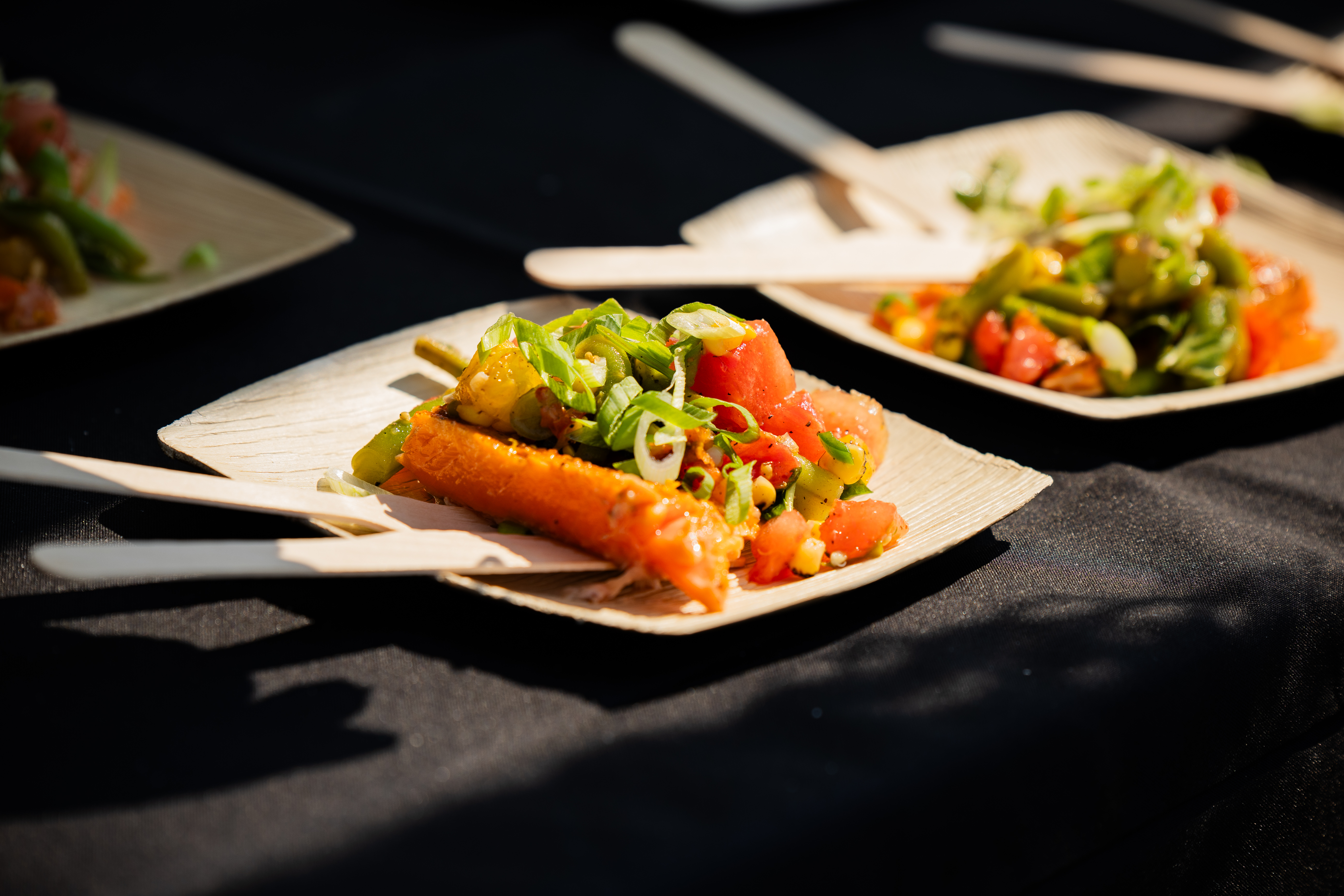 white square plates laid with fresh vegetables and smoked salmon at Radical Gardens.