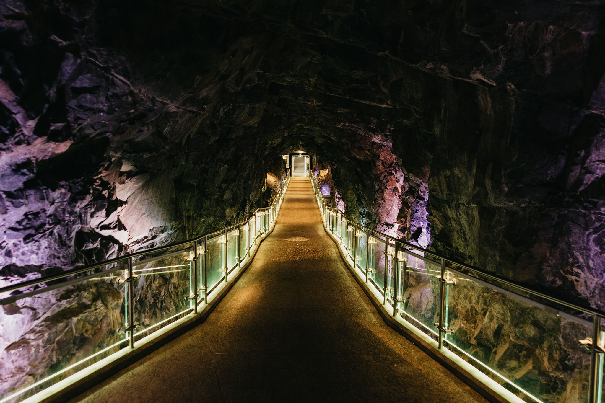an illumintated bridge leading into the dark rock caverns at Sciene North.