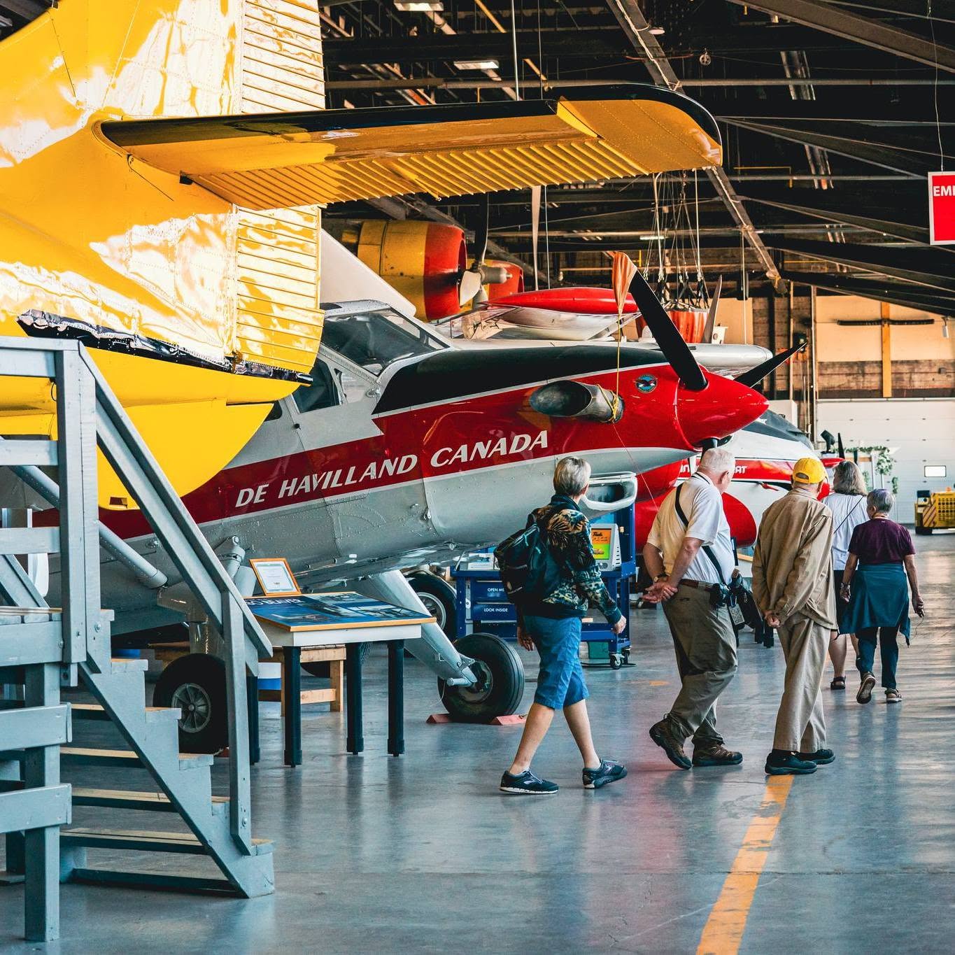 a group walks around the shiny bushplanes displayed in the hangar at the Bushplane Heritage Museum in Sault Ste. Marie.