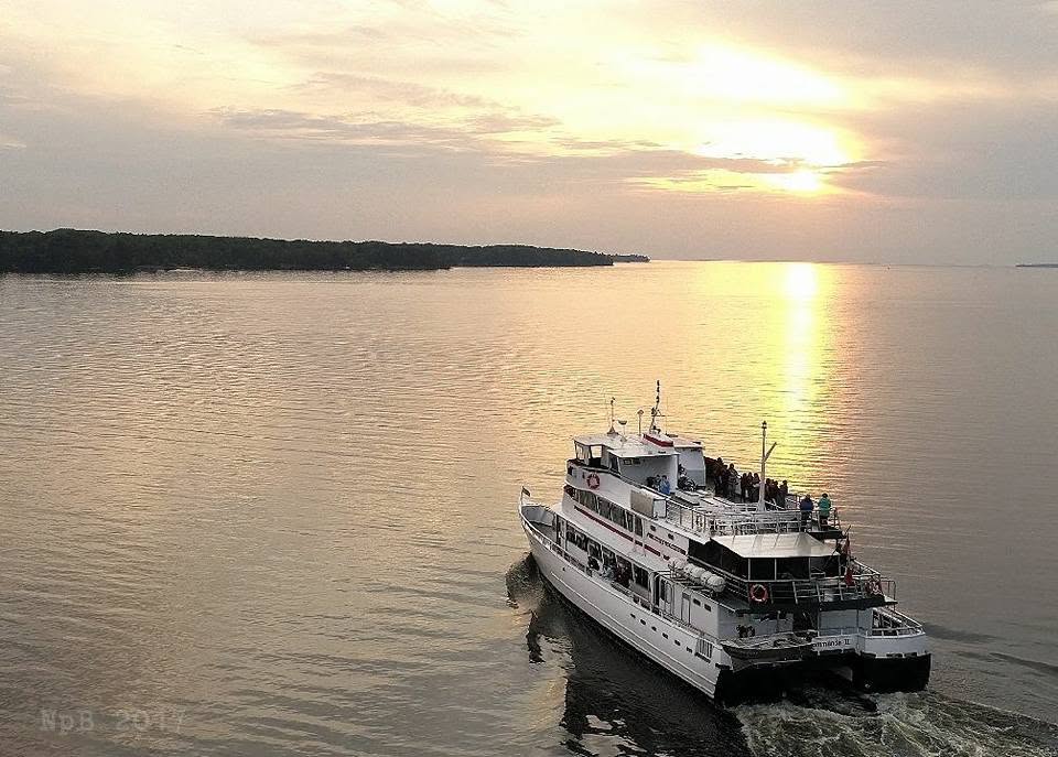 The Chief Commanda 2 sails into a golden sunset on the glassy calm water of Lake Nipissing.