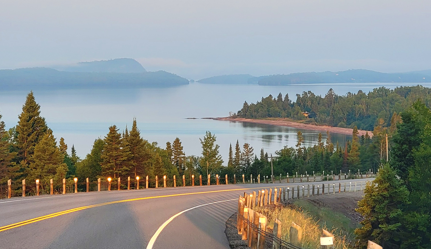 a softly lit, calm Lake Superior on a clear late summer morning along Highway 17 in Northern Ontario.