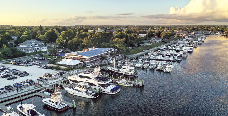 Flying Bridge Marina sprawling along a forest shore under a golden sunset.