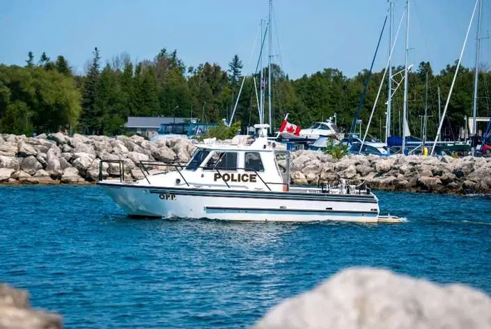 an Ontario Police patrol boat cruising on a blue bay. 