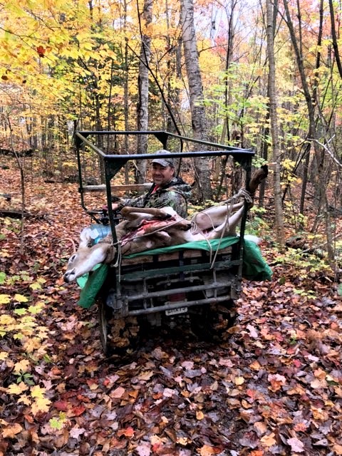 Jeff Morrison out hunting on a ATV in the autumn, with a buck laid across the back.