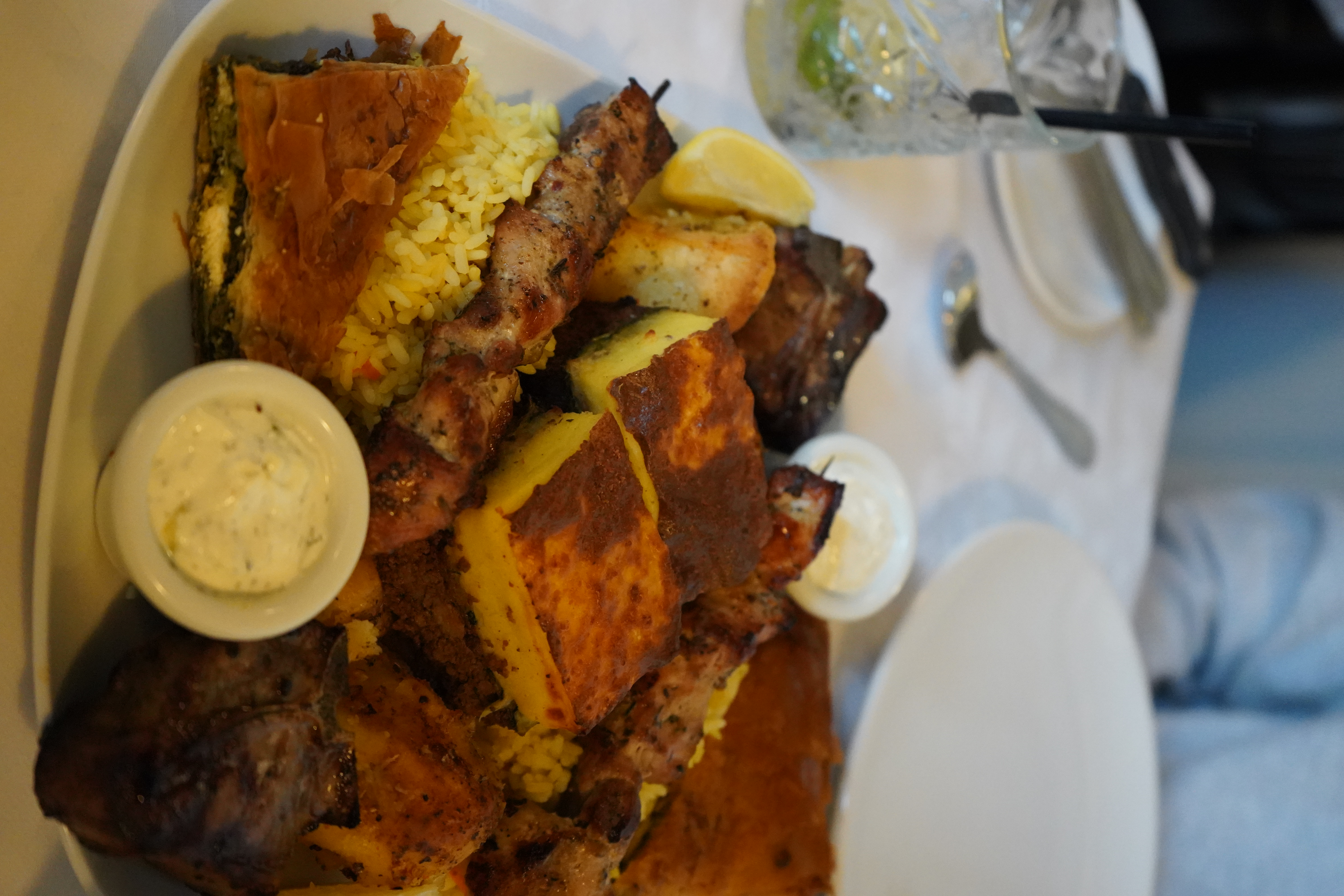 a plate of rice, souvlaki, hummus and bread from Apollo.