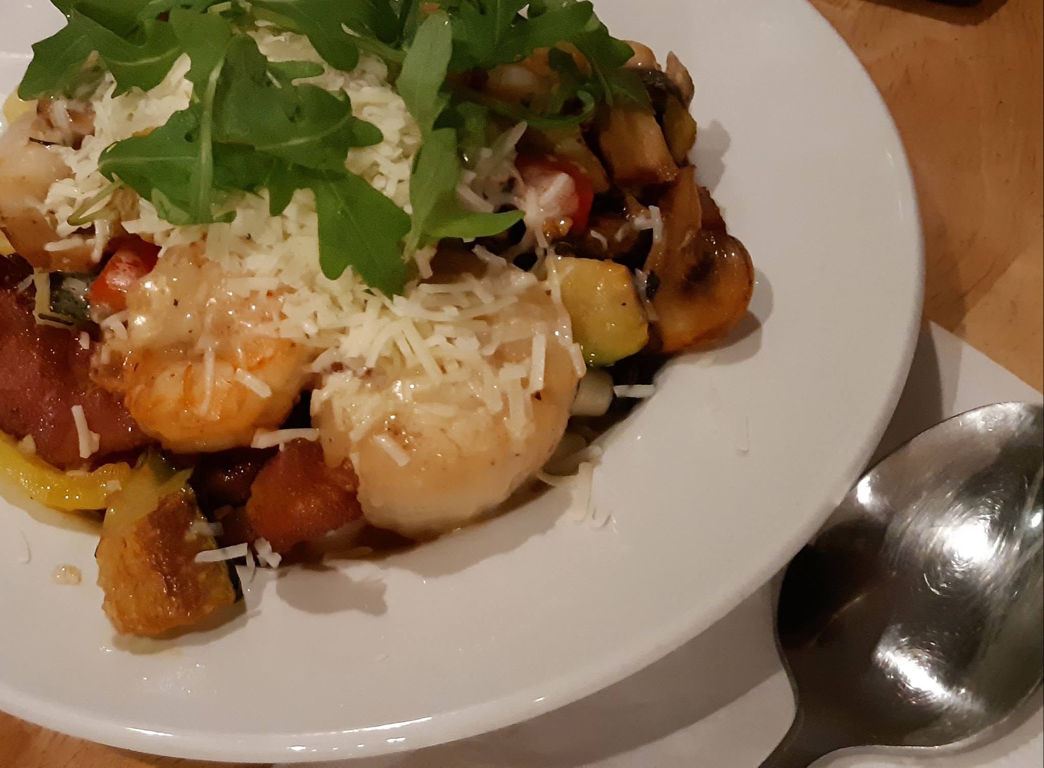 A plate of prawns and vegetables garnished with fresh herbs and cheeses at Marten River Lodge.