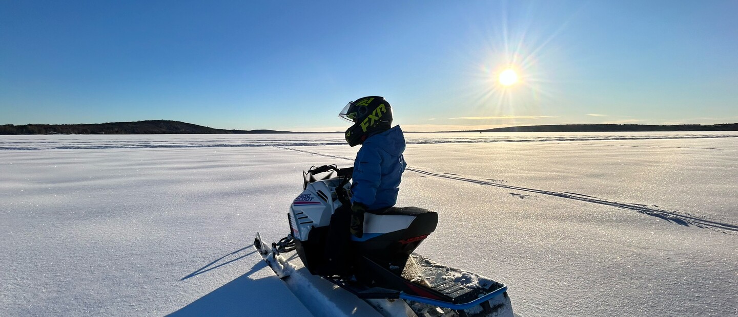 snowmobile and rider in wide open scene under blue skies