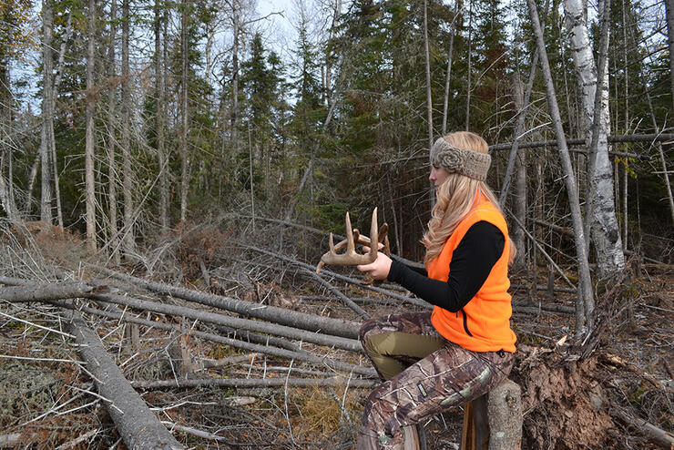 Corine  Armstrong uses a rattling antlers during a Northwestern Ontario Whitetail hunt