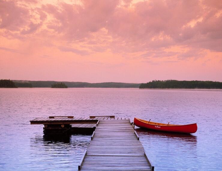 Dock leading into lake with canoe tied off