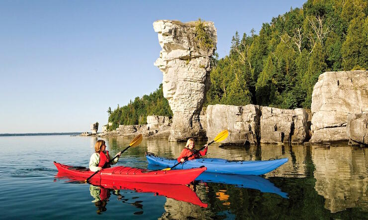 Two kayakers paddling in front of flowerpot island