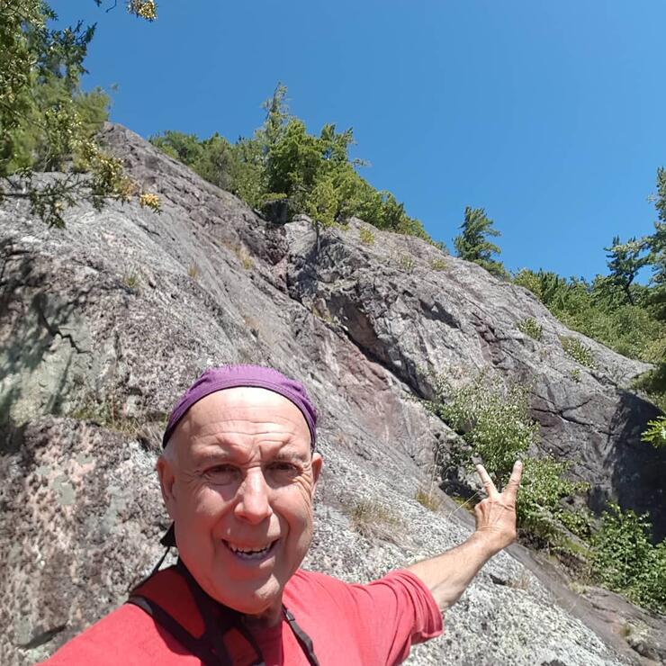 Man pointing at a rock face. 