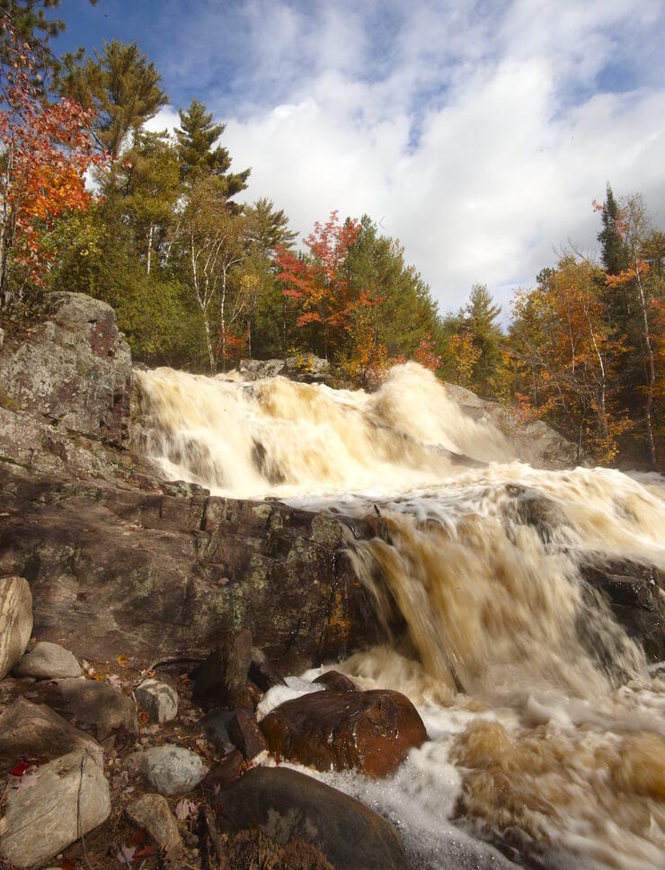 Large waterfalls flowing over rocks in autumn 