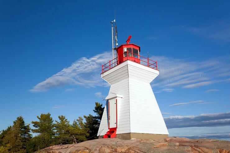 White and red lighthouse on a rock 