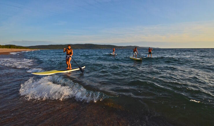 four SUP boards on Lake Superior with beach in background
