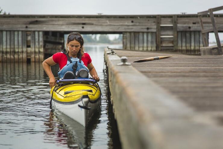 Woman sitting in kayak next to dock