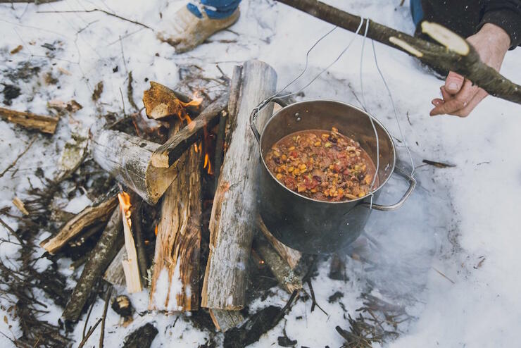 Pot of chili cooking over a fire