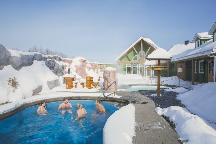 People in a hot tub in the winter at a spa.