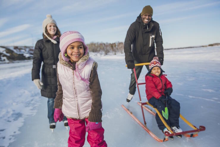 Family of four skating on lake. Ice skating is one of the best winter activities in ontario.
