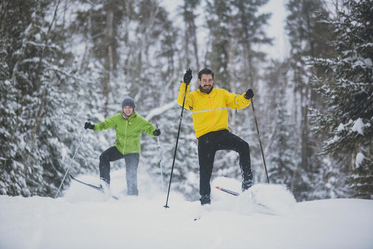 Man and woman skate skiing in powder snow. 