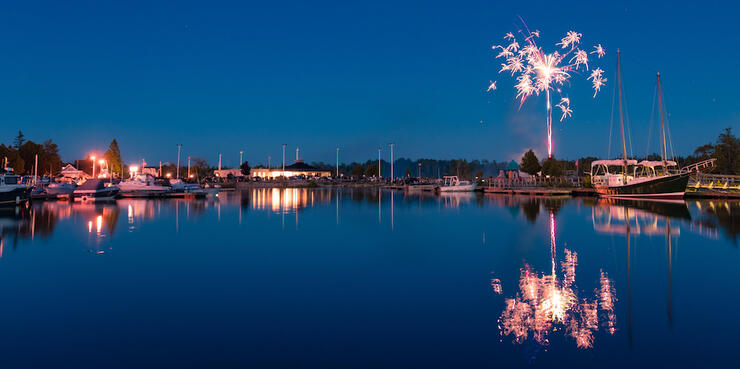 Fireworks in sky over harbour with boats 