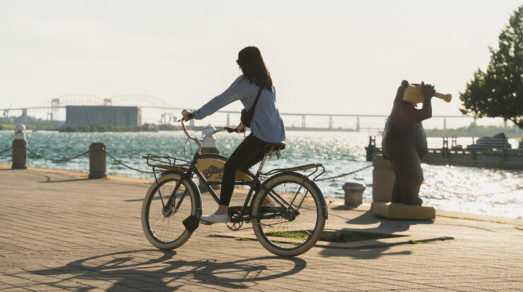 Woman cycling on the waterfront trail in Sault Ste. Marie.