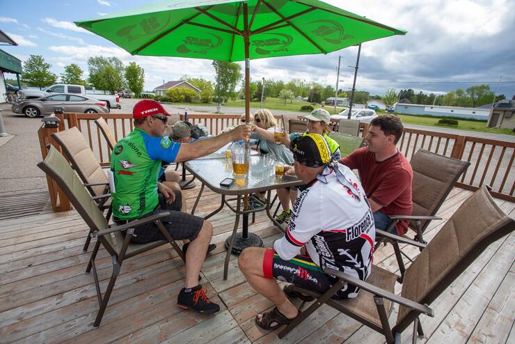 A group of cyclists enjoying food and drinks on a patio
