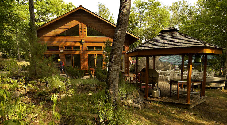Well kept lodge and cabana nestled in forest. 