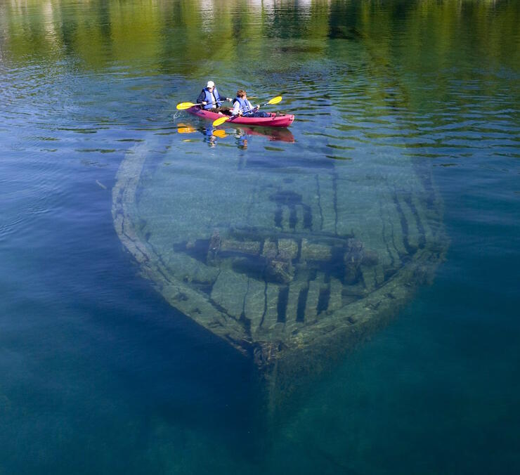 A kayak travelling over a submerged shipwreck 