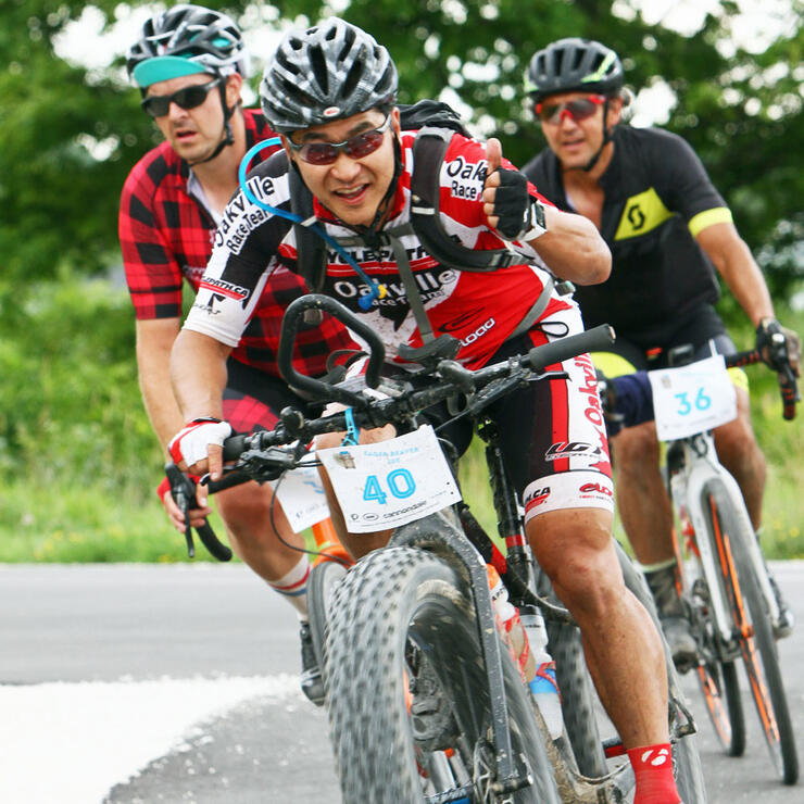 rider gives thumbs up while followed by two other riders in the Eager Beaver gravel bike race
