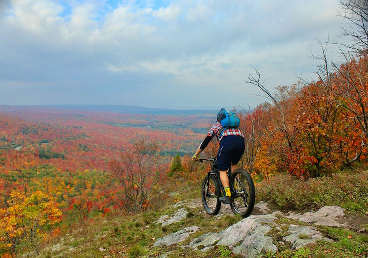 Cyclist riding a rocky path in fall on high hill