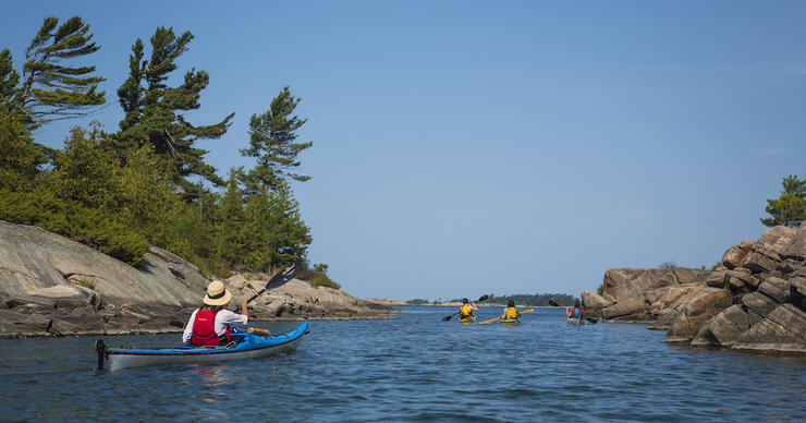 Group of kayakers paddling in a calm rock channel 