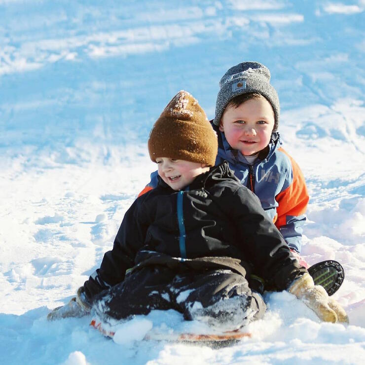 Two young boys on a toboggan.