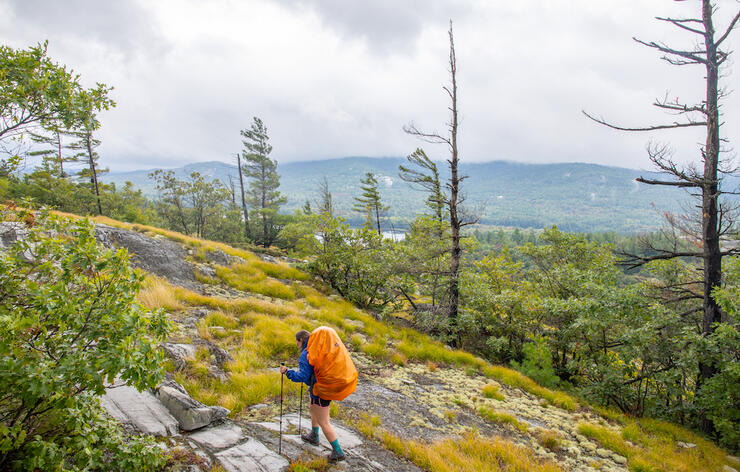 Woman with backpack hiking on a rocky trail