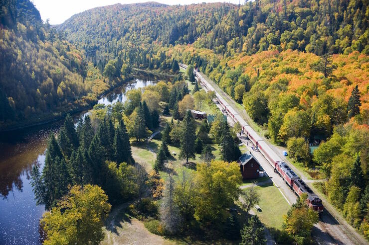 Aerial view in the fall of the train and tracks along a river. 