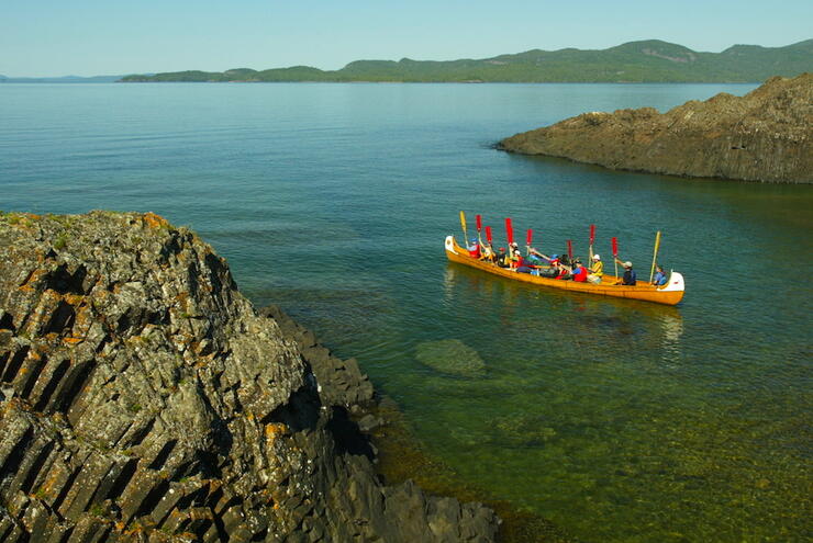 Voyageur canoe, with paddles up, in small bay on Lake Superior. 