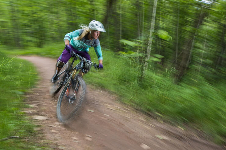 Woman in action mountain biking in forest