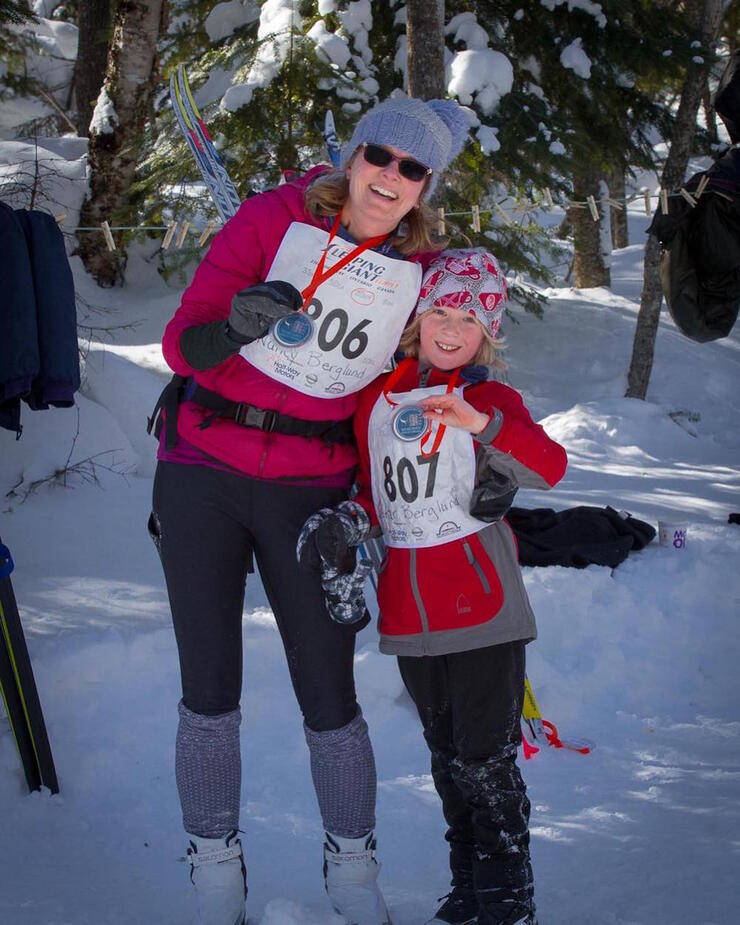 Woman and child showing metals from x-c ski race 